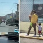 He walks around with his dog in his arms as if he were a child, while his young son walks